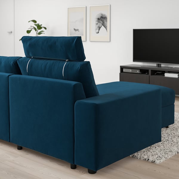 Sala de estar moderna com sofá secional VIMLE azul-petróleo, tv e decoração minimalista.