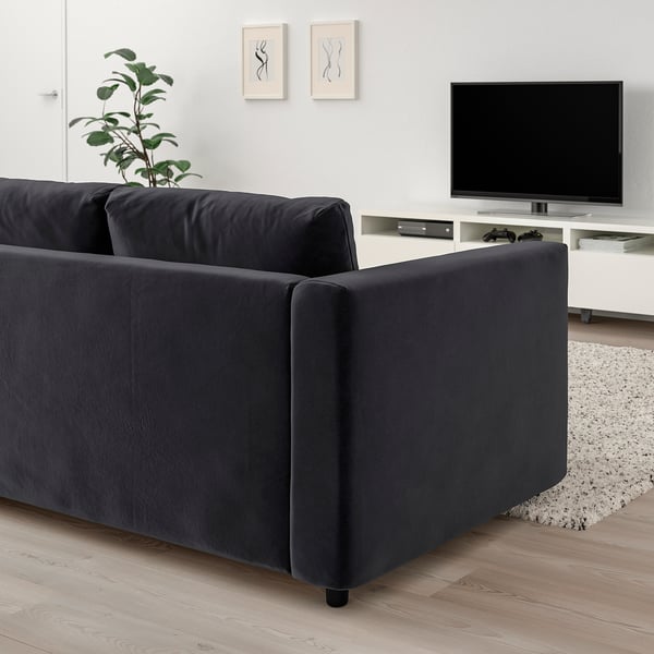 Sofá-cama VIMLE preto, design minimalista moderno, colocado no quarto com tv e planta.