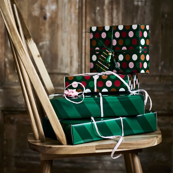 Duas caixas de presente festivas empilhadas em uma cadeira de madeira, prontas para presentes de Natal.