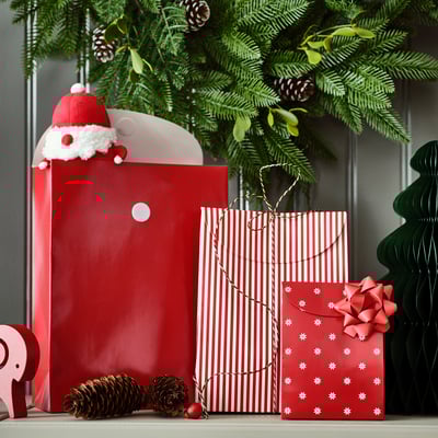 Sacolas de presente com tema natalino, decoradas com chapéu de Papai Noel, flocos de neve e pinhas. Perfeito para embrulhar presentes de forma rápida e fácil.