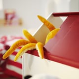 Tenda de pelúcia laranja no armazenamento de brinquedos vermelhos. Equipamento divertido e colorido para crianças.