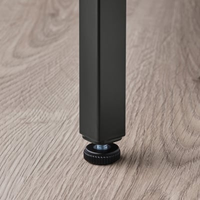 Perna de mesa ajustável em uma mesa de ninho VITTSJÖ , garantindo estabilidade em pisos irregulares.