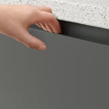 Punho integrado de aperto manual do armário VOXTORP cinzento escuro, mostrando o seu design suave e facilidade de utilização.