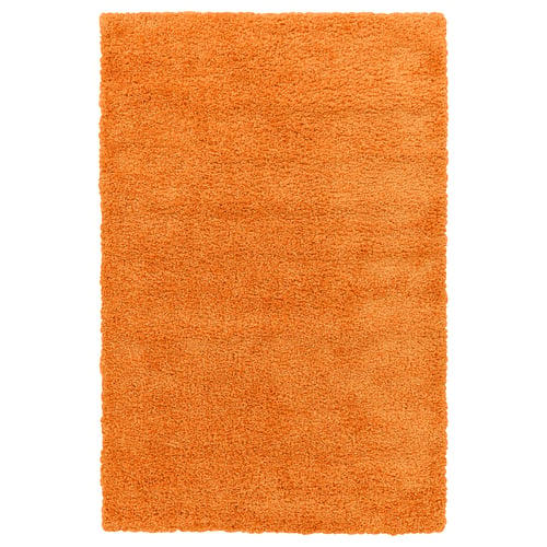 An orange, rectangular rug named ÄRENDE with a soft, shaggy surface made from polypropylene.