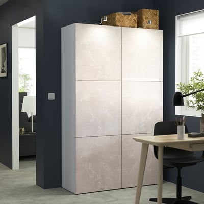 Beige BESTÅ storage unit with 6 doors against dark wall.