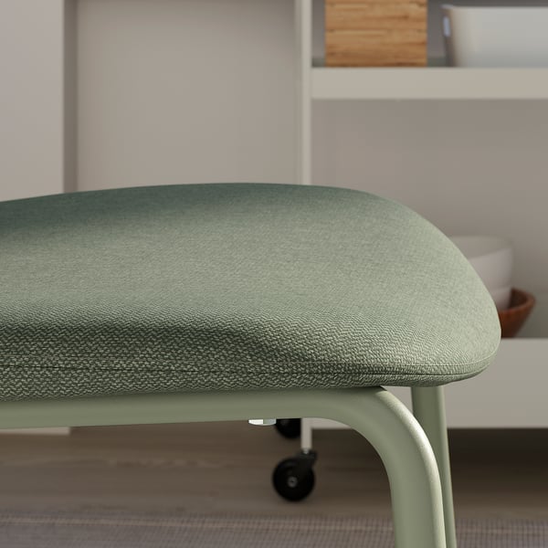 Close-up of a green upholstered office chair, showcasing its smooth fabric and sturdy design.