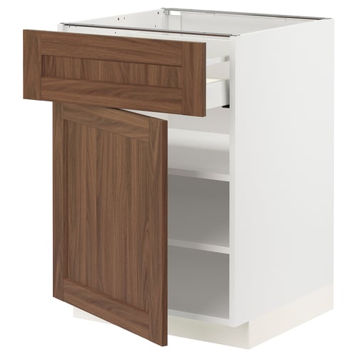 A white cabinet from IKEAs METOD kitchen system with a brown wooden door and drawer. It a drawer and an open shelf.