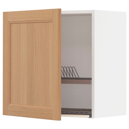 An open light oak kitchen cabinet with a dish drainer inside.