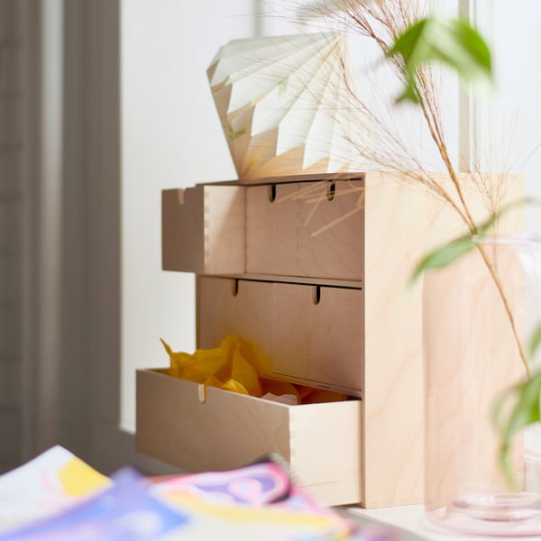 Wooden MOPPE mini chest with drawers by window, organising small items.
