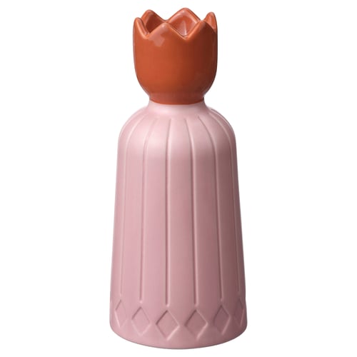 Pink ceramic candle holder, ornate top, classic shape.