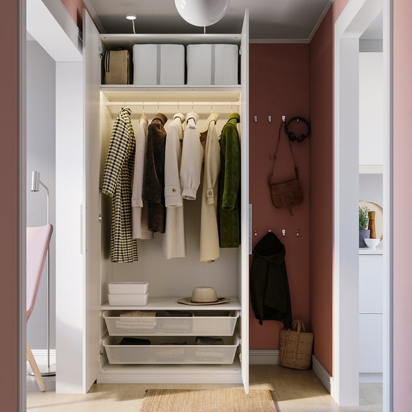 Open closet showing clothes, accessories, and storage boxes inside. Soft-closing door with visible hinges and adjustable legs.