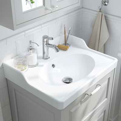 A white RUTSJÖN ceramic wash-basin with a raised backsplash and oval bowl, designed for traditional appeal, with a 10-year guarantee.