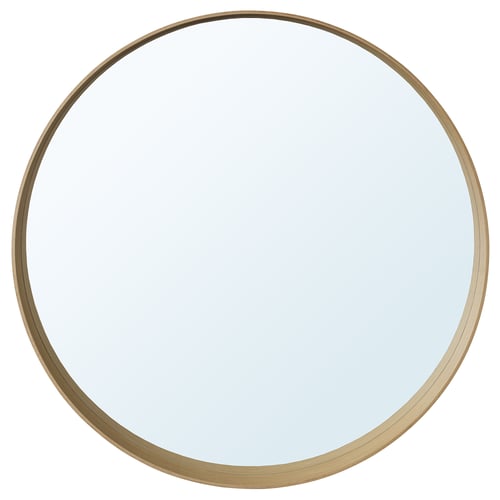 A STOCKHOLM mirror with a light oak frame and a round shape. The frame has a shelf at the bottom.