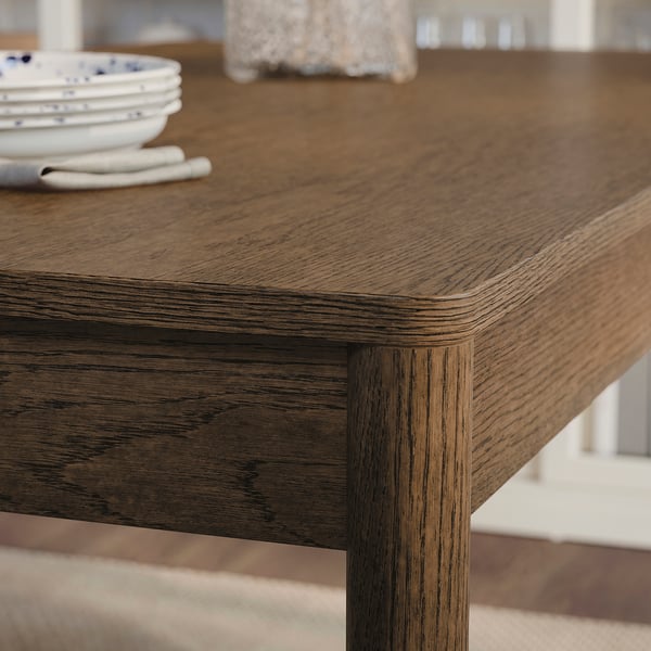Wooden table close-up, showcasing smooth, natural oak veneer with visible grain texture and rounded edges, highlighting quality craftsmanship.