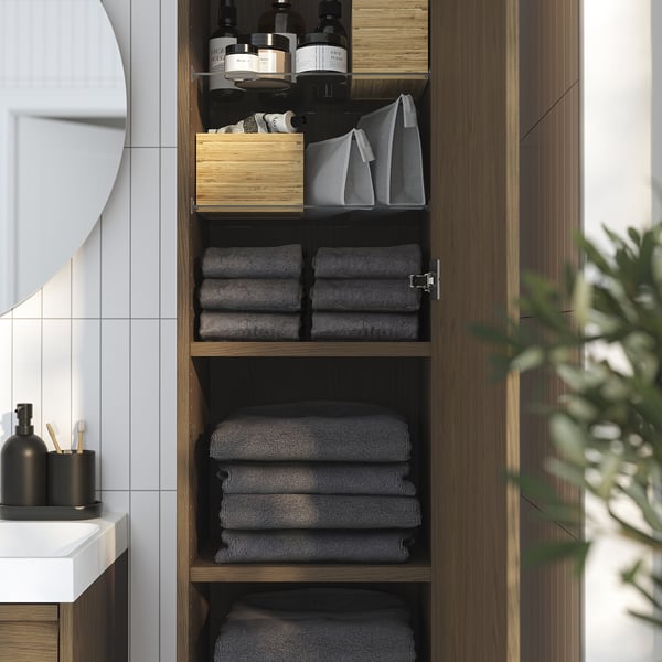 Dulap de baie modern cu rafturi, prosoape, sticle și design elegant.