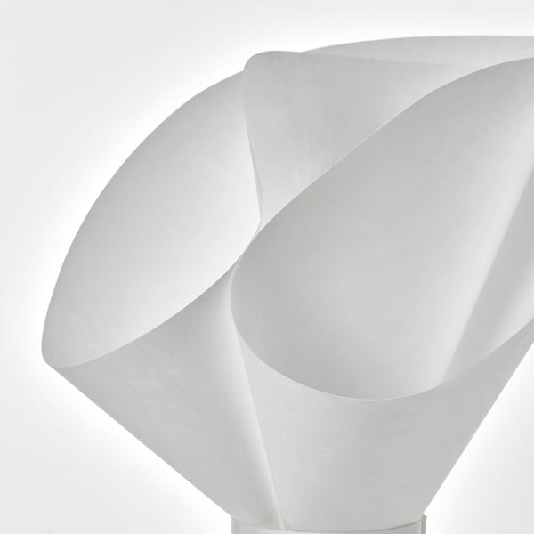 Lampă de masă albă, modernă, cu un design curbat, asemănător unei flori, care aruncă o lumină blândă.