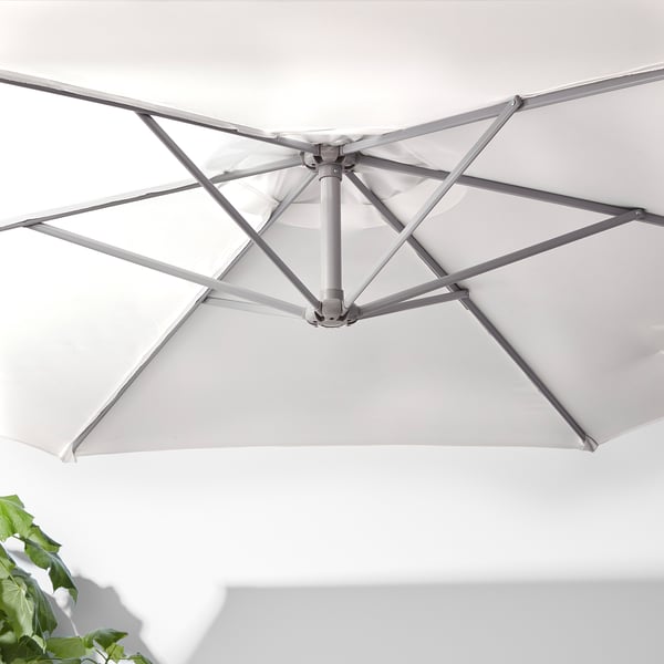 O umbrelă de soare albă de înaltă calitate, cu un cadru metalic robust, cu sistem de aerisire și manivelă pentru deschidere și închidere ușoară.