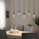 Cinci lămpi BENGTSBOL în cascadă strălucesc deasupra mesei cu decor elegant.