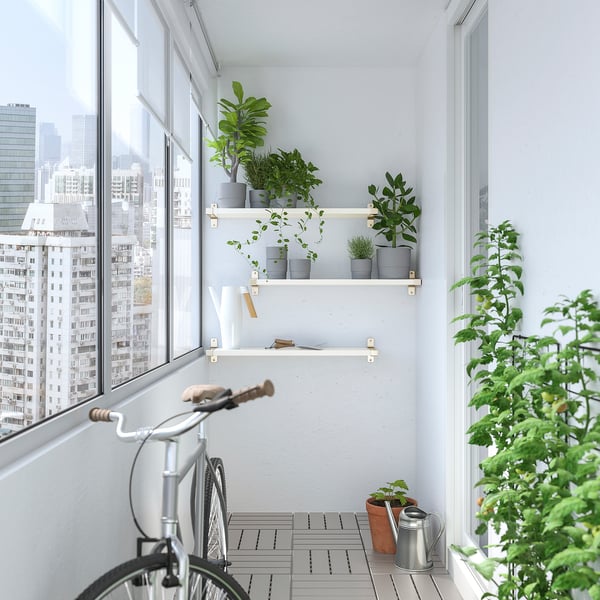 Balcon al orașului cu plante, bicicletă și orizont urban.