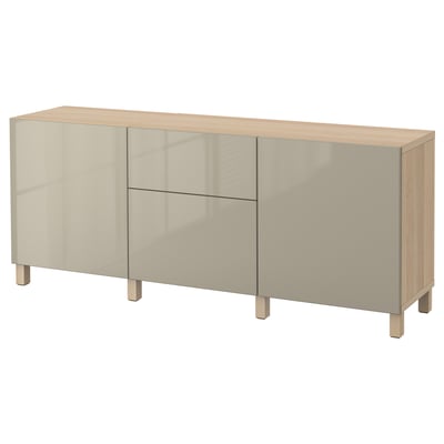 Un bufet ikea BESTÅ alb cu picioare din lemn, cu trei secțiuni: două cu uși de sticlă și un raft deschis.