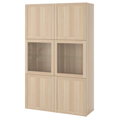 Un dulap de depozitare ikea BESTÅ maro deschis. Are patru secțiuni: două cu uși de sticlă și două uși solide, afișând un design modern și minimalist.