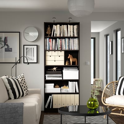 Living minimalist cu bibliotecă BILLY, canapea albă și măsuță de cafea.
