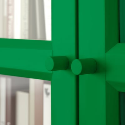 Bibliotecă verde cu uși din sticlă, cu design robust și rafturi reglabile pentru depozitare versatilă.