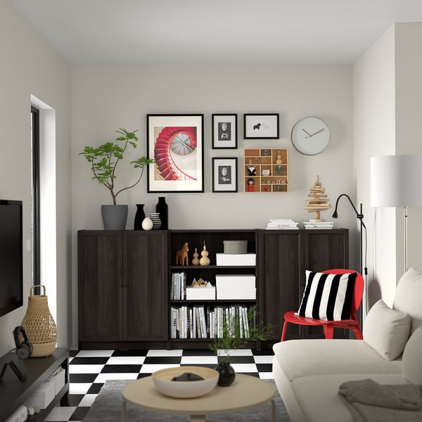 Living modern cu bibliotecă BILLY, canapea, scaun cu dungi, măsuță de cafea și perete galerie.