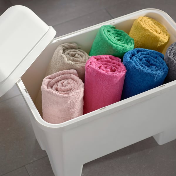Coș de depozitare din plastic alb, capac deschis, ținând prosoape rulate îngrijit de diferite culori.