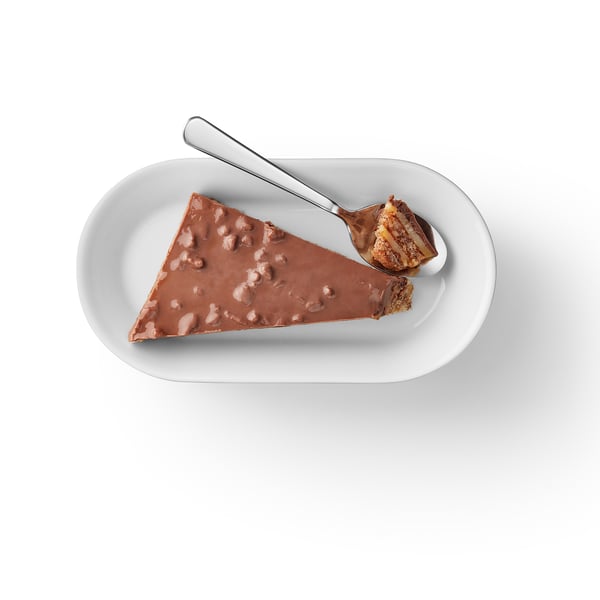 Caramel de migdale acoperit cu ciocolată pe farfurie cu lingură