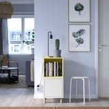 Living modern cu pereți albaștri, unitate EKET, cactus și imprimeuri artistice. Scaun alb în apropiere.