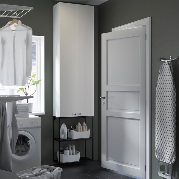 Amenajare modernă a spălătoriei albe cu dulapuri înalte și de perete, mașină de spălat albă, design curat.