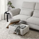 Canapea modernă cu tetiere reglabile și otoman cu depozitare, perfectă pentru relaxare și spațiu ordonat.
