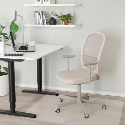 Scaun de birou IKEA FLINTAN alb cu spătar din plasă, lângă birou cu laptop, compact și ergonomic pentru ore lungi de lucru.