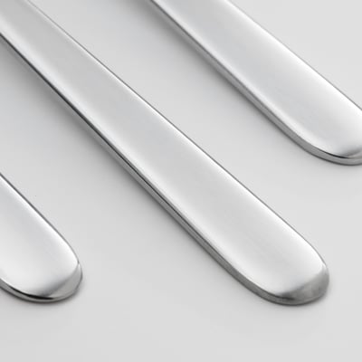 Patru lingurițe din argint lustruit aliniate una lângă alta, design elegant și simplu, din oțel inoxidabil.