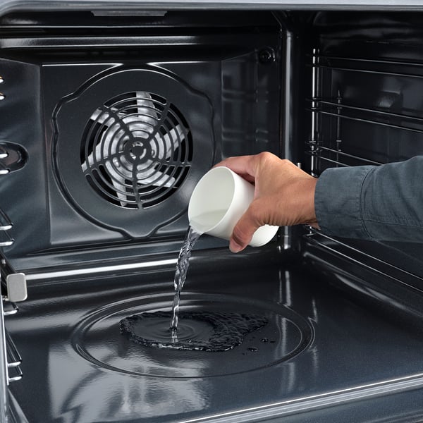 Turnarea apei într-un cuptor, demonstrând funcția de curățare a cuptorului.