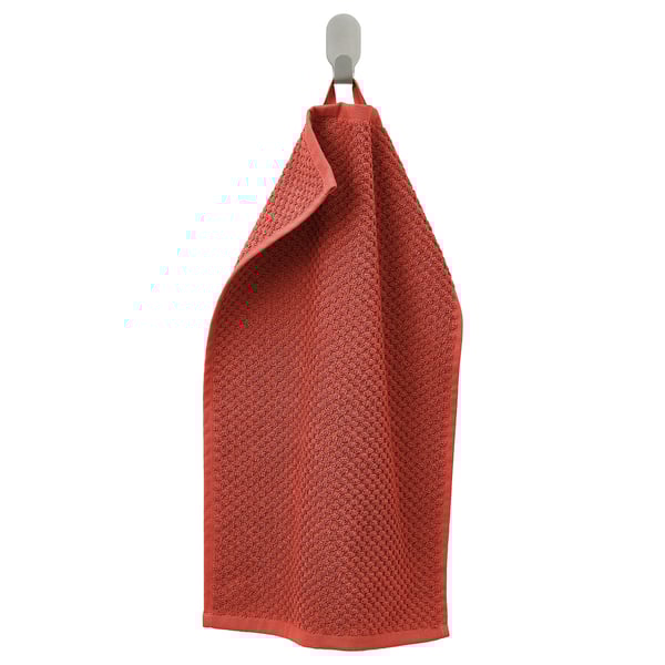 Un prosop roșu numit GULVIAL atârnă de un cârlig. Fabricat din bumbac 100%, este moale, absorbant și pufos. Prosopul este dreptunghiular și are o textură terry.