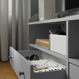 Un televizor modern cu trei sertare, unul deschis cu căști și o revistă. Include opțiuni de gestionare a cablurilor și de atașare pe perete.