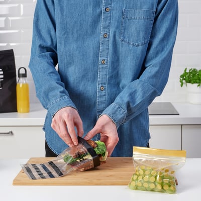 Sunt prezentate două pungi de depozitare ikea transparente, resigilabile, una cu dungi negre și cealaltă cu puncte aurii, din plastic din polietilenă.