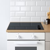 Bucătărie modernă cu unități modulare KNOXHULT. Plită cu inducție din sticlă neagră și dulap alb cu butoane de control.