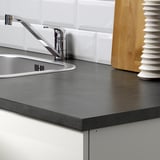Zonă modernă de chiuvetă de bucătărie cu robinet metalic și blat întunecat, parte a designului modular.