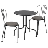 Set de mobilier de exterior negru cu masă rotundă și două scaune stivuite cu perne circulare și rame metalice. Design modern, minimalist.