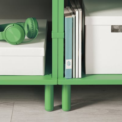 Raft de depozitare verde cu căști și cărți, picioare reglabile.
