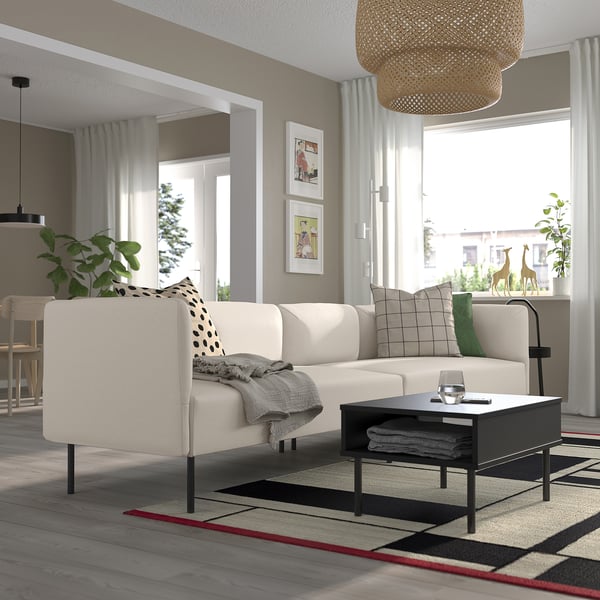 Living modern cu canapea LILLEHEM, perne, măsuță de cafea, masă laterală cu plante și covor mare.