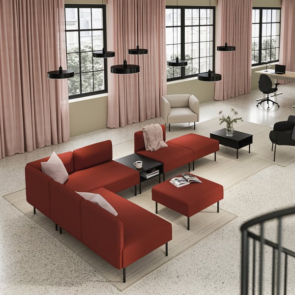 Spațiu de locuit modern cu canapea roșie LILLEHEM, covor, mese negre, lumini suspendate, draperii roz și lumină naturală de la ferestre mari.