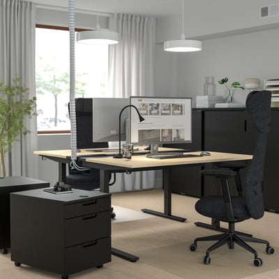 Birou modern de acasă: birou METTZON, scaun reglabil, ergonomic, lumini, computer, plante.