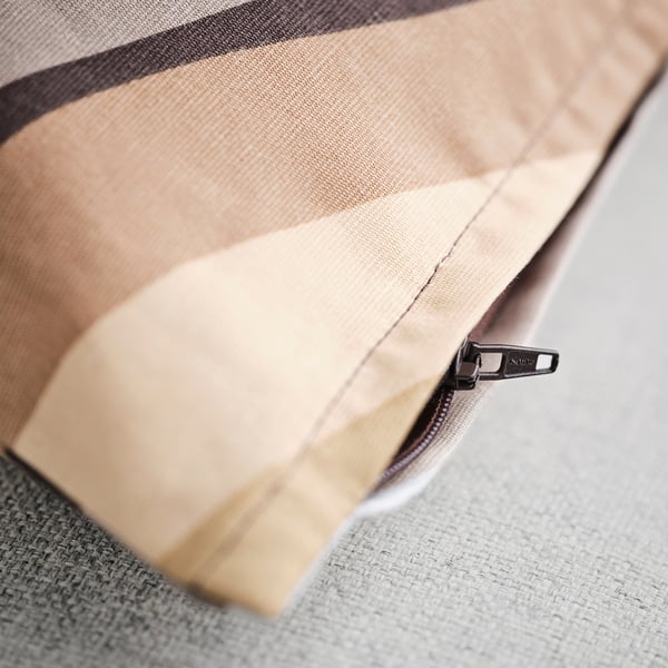 Prim-plan al unui fermoar pe o husă de pernă, prezentându-i calitatea și designul.