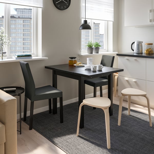 Bucătărie modernă cu masă și scaune NORDVIKEN, vedere urbană, decor vegetal.