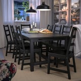 Set de sufragerie negru modern cu masă extensibilă și scaune cu spătar de scară. Iluminat moale, veselă în dulap de sticlă.