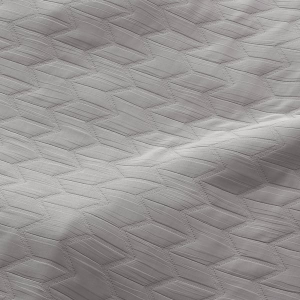 Prim-plan cu o perdea moale, din poliester reciclat, cu textură complicată, țesută jacquard, care oferă eficiență energetică și intimitate.